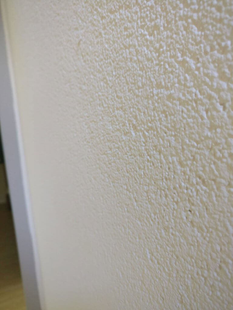 Spachtelputz op een muur bij een deur